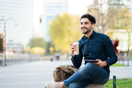 Young man using digital tablet outdoors.の写真素材