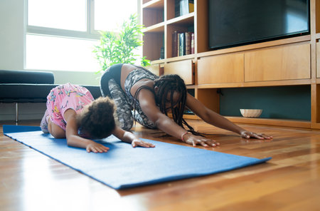 Mother and daughter exercising together at home.の写真素材