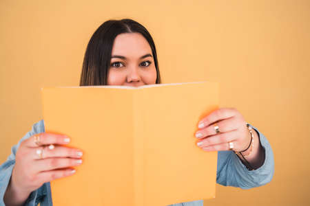 Young plus size woman reading a book.