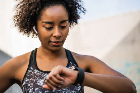 Fitness woman checking time on smart watch.の写真素材