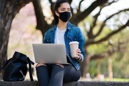 Young woman using her laptop outdoors.の写真素材