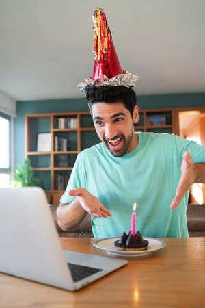 Man celebrating birthday online from home.の写真素材