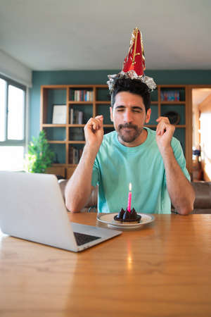 Man celebrating birthday online from home.の写真素材