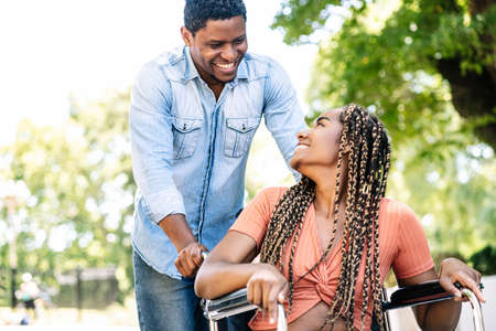 Woman in a wheelchair enjoying a walk with her boyfriend.の写真素材