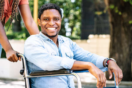 Man in a wheelchair smiling and looking at camera.の写真素材