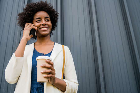Business woman talking on the phone outdoors.の写真素材
