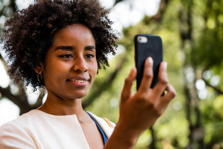 Afro business woman having a video call on mobile phone.の写真素材