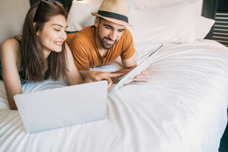 Couple organizing their trip at hotel room.の写真素材