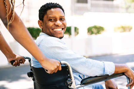 Man in a wheelchair smiling and looking at camera.の写真素材