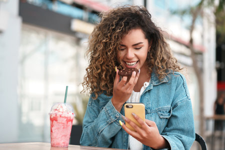 Latin woman using a mobile phone while sitting at a coffee shop.
