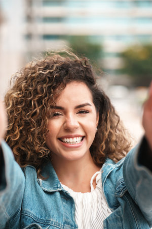Young latin woman taking selfies outdoors.の写真素材