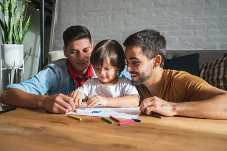 Gay couple having fun with their son at home.