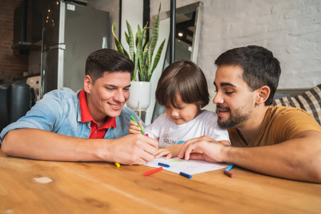 Gay couple having fun with their son at home.の写真素材