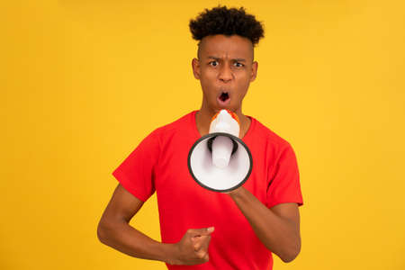 Angry man screaming through a megaphone to raise his voice up.