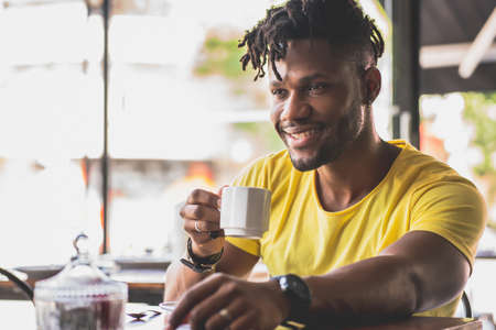 Man drinking a cup of coffee at a coffee shop.の写真素材