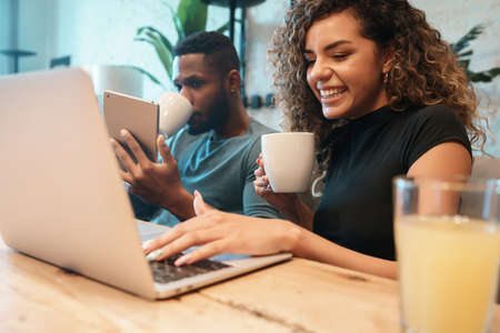 Couple using laptop and digital tablet at home.