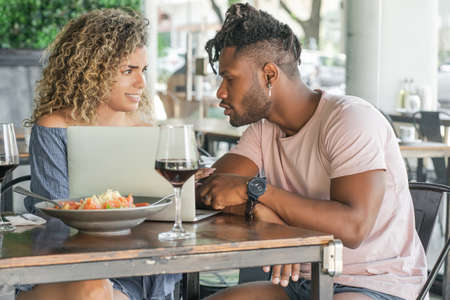 Couple using a laptop while having lunch together.の写真素材