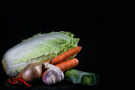 Isolated vegetables: cabbage, onion, leak, garlic, carrot. Traditional cuisine from Korea. Kimchi - Korean ingredient on stone plane.の写真素材