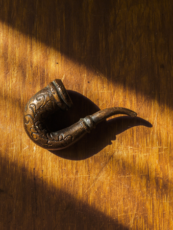 Old smoke tobacco pipe lies on the scratched wooden board. Copy space.の写真素材