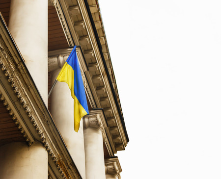 blue-yellow flag of Ukraine on the flagstaff of the old manor building isolated on a white background. National flag of Ukraine in Ukraineの写真素材