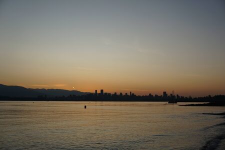 Sunrise over city at waterの写真素材