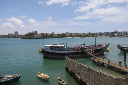 Mombasa, Kenya - September 17, 2017: Ship in the Mombasa harbor, young workers carrying bags of food to the landのeditorial素材