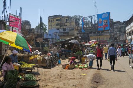 Varanasi, India - March 25, 2017, Travelling through India: Street scene with tuk-tuk, bicycle and market sellersのeditorial素材