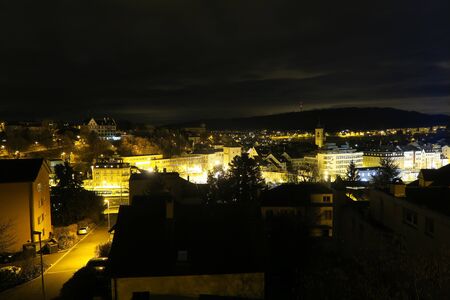 Schaffhausen, Switzerland, February 8 2017, Bright yellow city lights of Schaffhausen at night time. Munot and Highschool building in the background.のeditorial素材