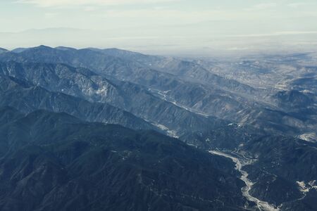 Mountain and canyon view, clouds and blue sky above Arizona, Utah and Colorado during the flight to LAの写真素材