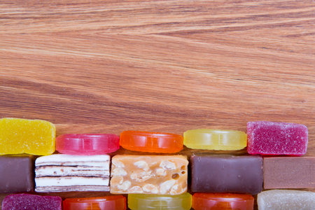 mix of different types of candies on a wooden boardの写真素材