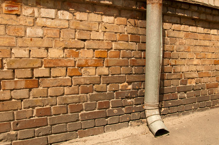 part of an old brick wall with a pipe drainageの写真素材