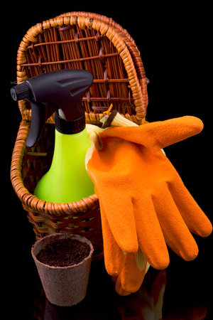 peat pots for seedlings, rakes, orange gloves and a basket on a black backgroundの写真素材