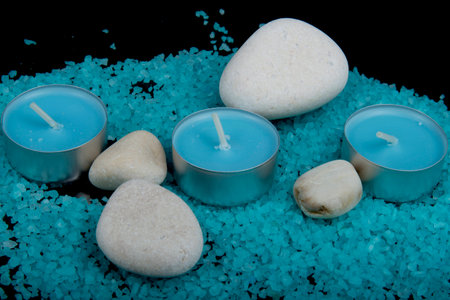 Spa composition in blue, candles and blue sea salt with stones on a black backgroundの写真素材