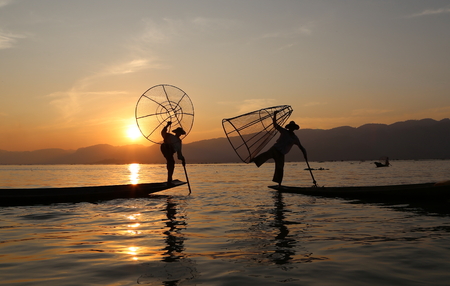 Traditional fishermen at work during the sunset, Myanmarの写真素材