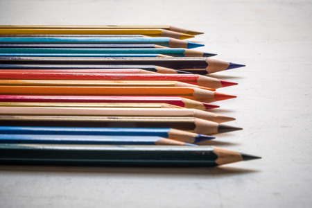 Colour pencils isolated on white wood background close up. Horizontal arrangementの写真素材
