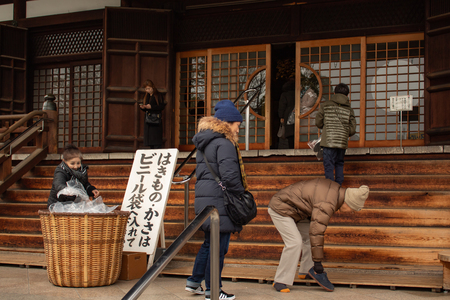 OSAKA, JAPAN - JAN 29, 2018: Japanese people taking of shoes before entering to temple in Osakaのeditorial素材