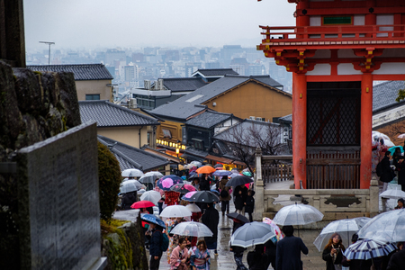 KYOTO, JAPAN - 10 FEB 2018: Aerial shot of people walking on a path at Kiyomizu Dera Temple wearing umbrellasのeditorial素材