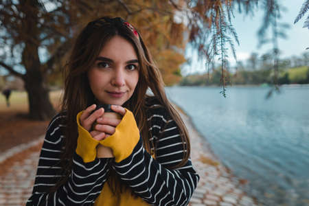 Close up with copy space of a pretty caucasian woman holding a cup of coffee to go.の写真素材