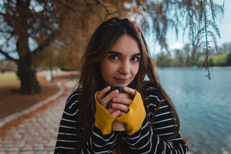 Close up shot of a pretty caucasian woman holding a cup of coffee to goの写真素材