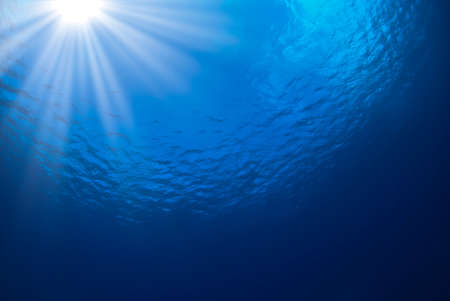 Ocean blue background with rays of sunの写真素材