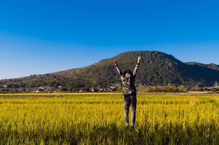 The happy man leaped on the fieldの写真素材