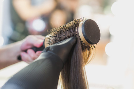 blowdrying hair on round brushの写真素材