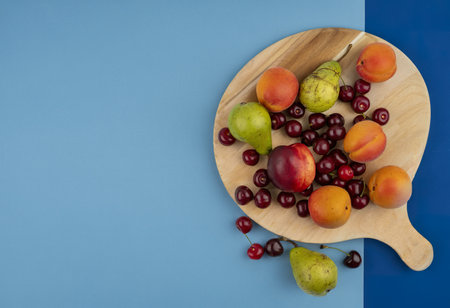 top view of pattern of fruits as peach pear apricot cherry on cutting boardの写真素材