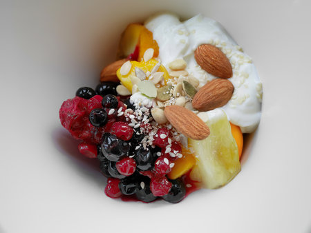 close-up of top view vibrant color fresh mixed berries almond nuts and fruits with greek yoghurtの写真素材