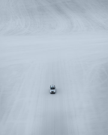 Car driving down a black road