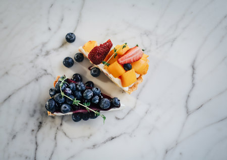 Tasty blueberry pie and mango with strawberry tart on white marble table backgroundの写真素材