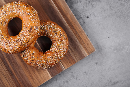 Healthy organic whole grain bagel on wooden board on concrete background tableの写真素材