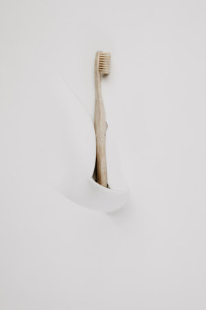 Hand holding a wooden toothbrush