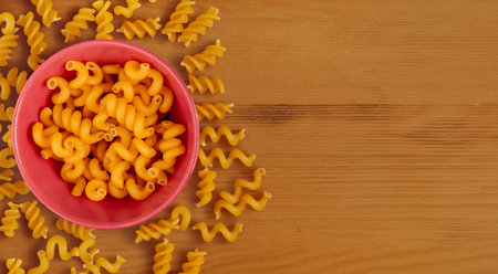 top view of pasta in bowl on wooden background with copy spaceの写真素材