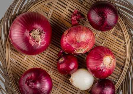 top view of red and white onions in basket plate with sliced white one in bowlの写真素材